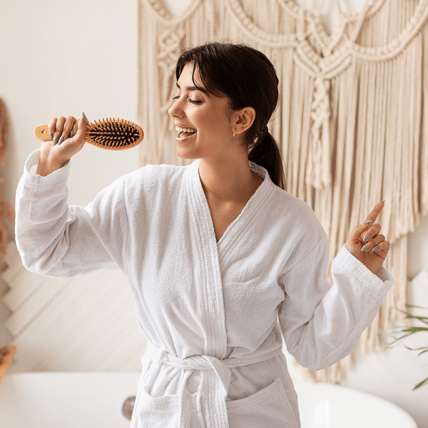 Woman pretending her hairbrush is a microphone